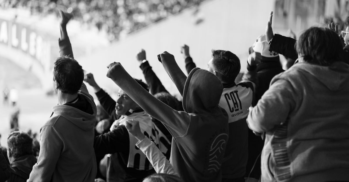 A crowd of enthusiastic football fans cheering inside a stadium in Córdoba, Argentina.